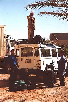Expedition preparation, Aid (top of Land Rover), Lahcen (left) and a helper (right).