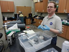 UCF Laboratory - Bob Macke, using glass beads to measure bulk density of oriented 9.9 gram Sutter's Mill stone. May 2012